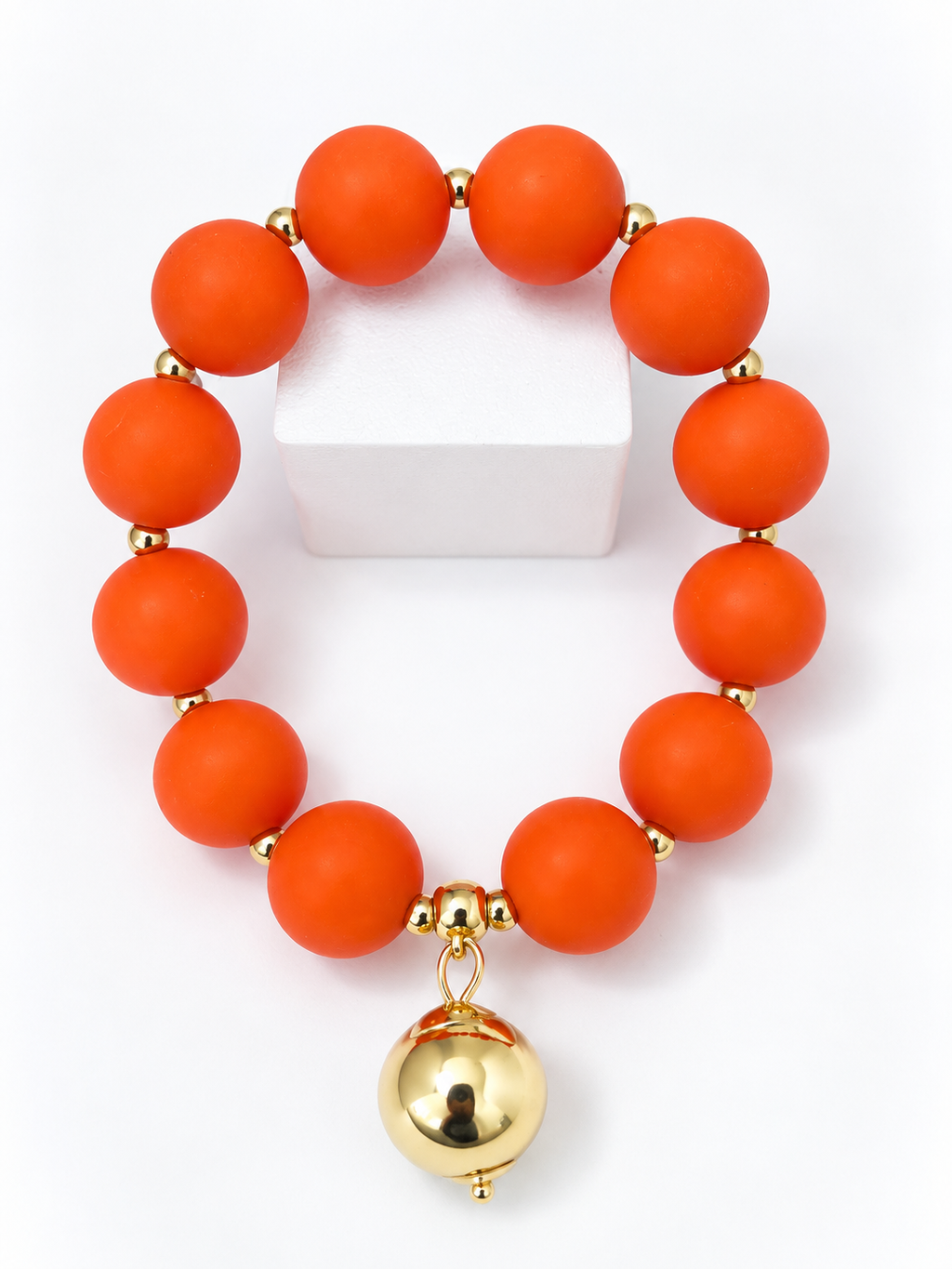 Orange beaded bracelet with gold drop