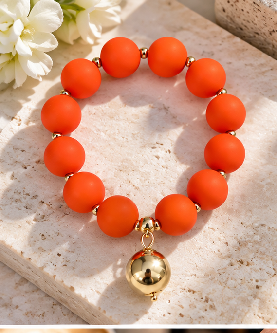 Orange beaded bracelet with gold drop