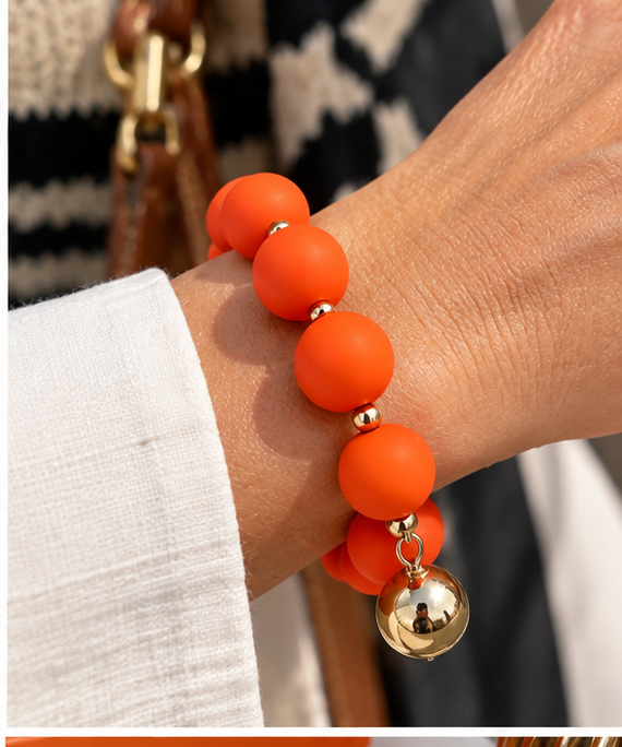 Orange beaded bracelet with gold drop
