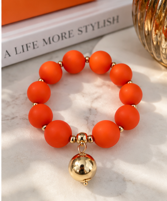 Orange beaded bracelet with gold drop
