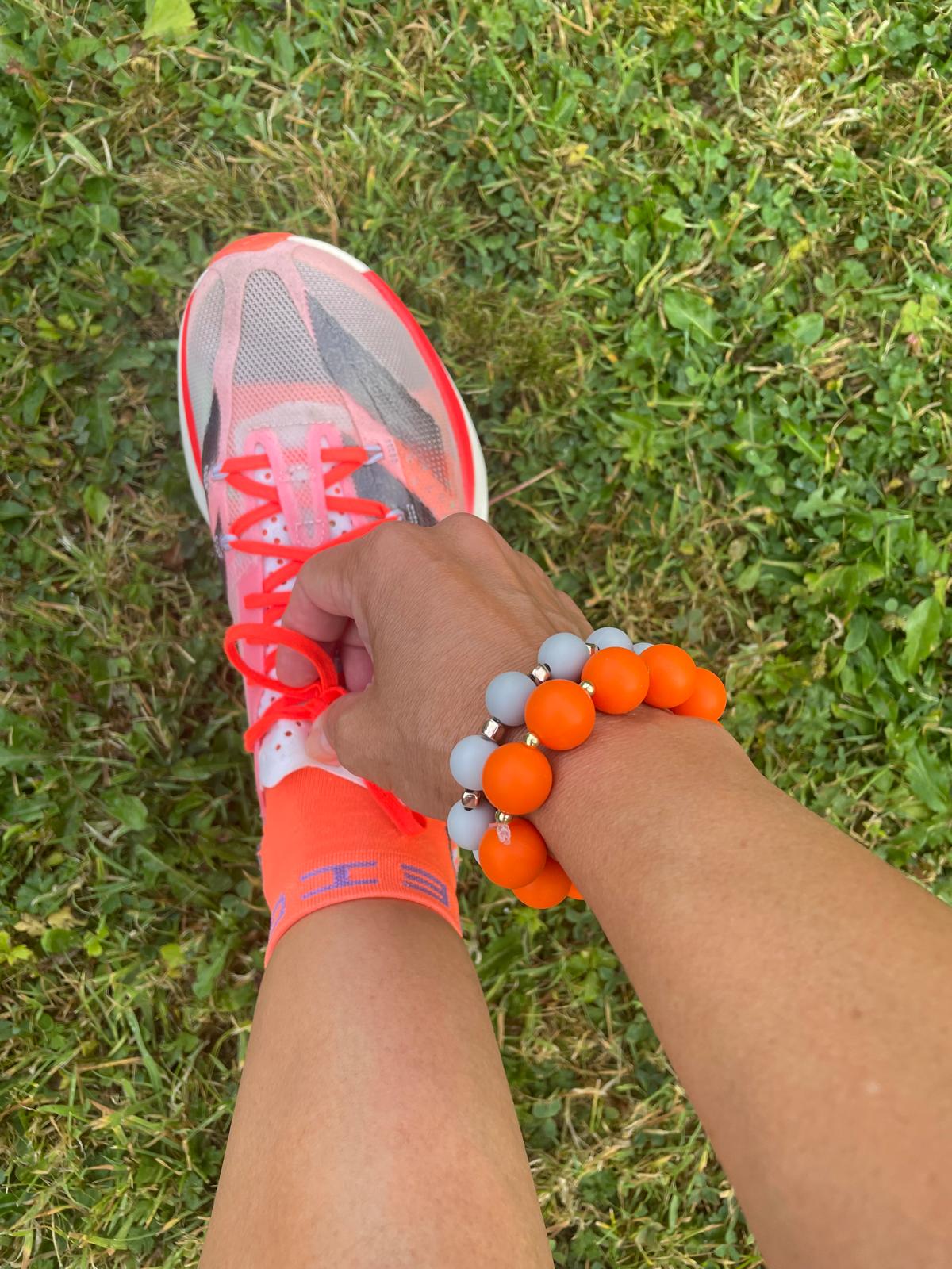 Orange beaded bracelet with gold drop